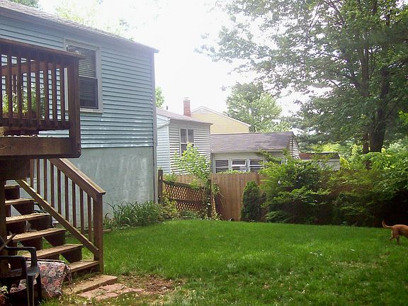 Back of house towards privacy fence, shrubs and HUGE Butterfly bush