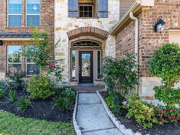 Mature landscaping surrounds the Covered Front Porch and walkway for an inviting entrance for all your guest!