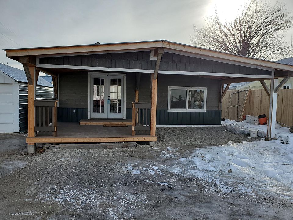 Front garden door on the covered deck. Also, shows the carport on the right and storage building on the left.