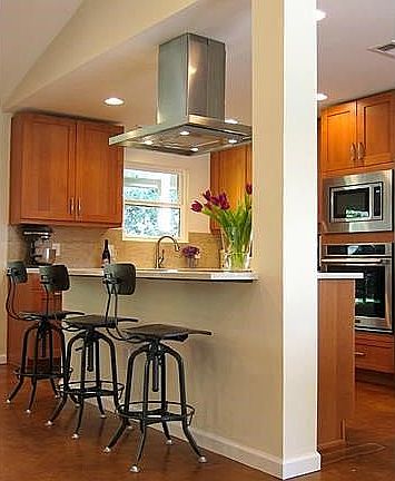 Kitchen island with induction cooktop and hood with plenty of room for seating.