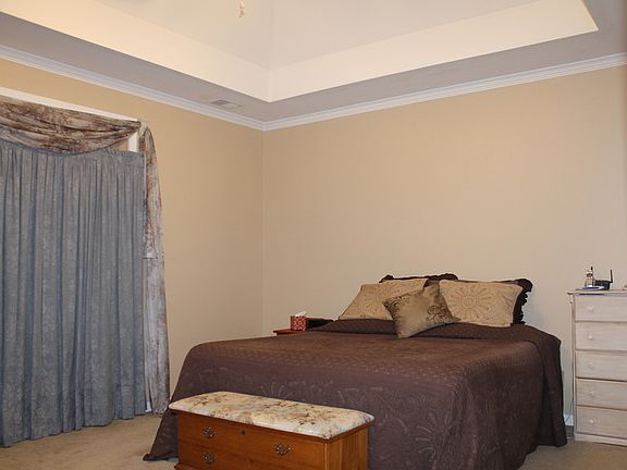 The master bed room has a trey ceiling with a fan.