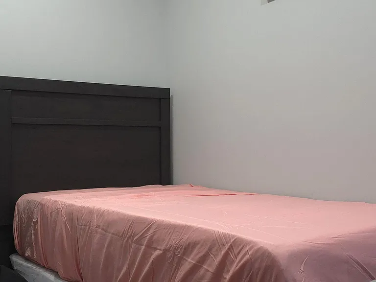 Private bedroom with a full bed, sturdy headboard, and neutral wallsan easy-to-furnish space for rest and study.