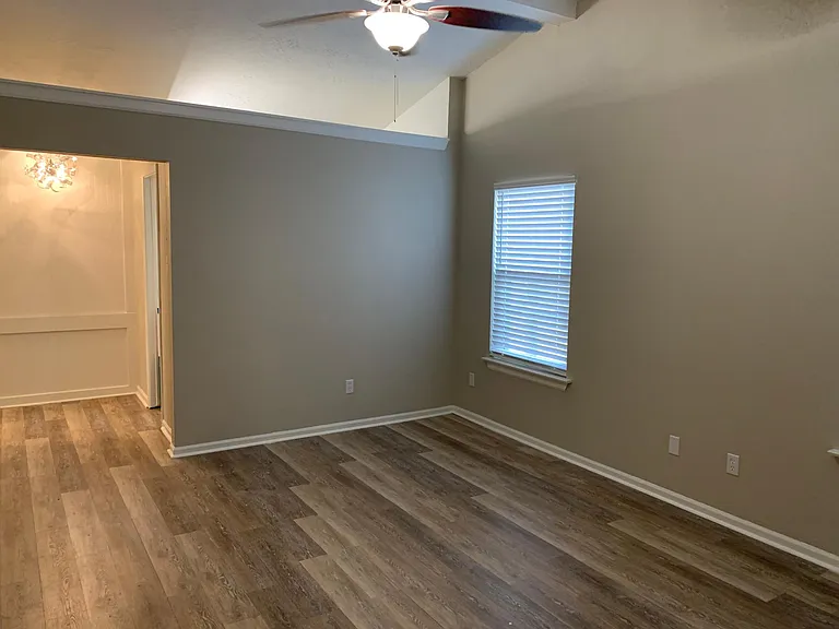 Large primary bedroom with vaulted ceiling. Vinyl plank flooring.