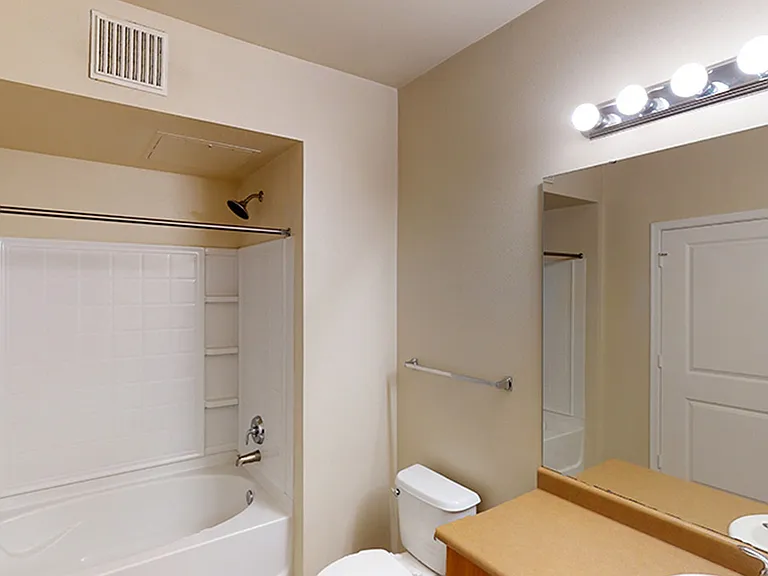 Apartment bathroom with wood-style flooring.