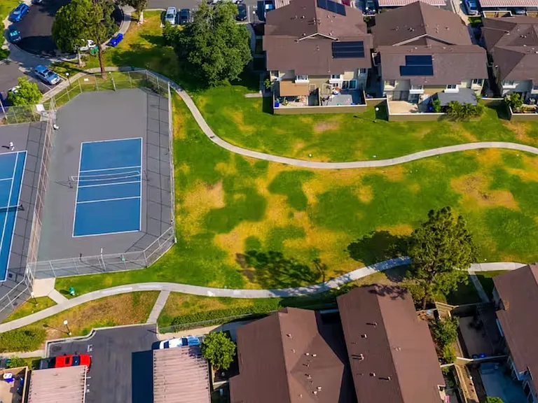 Tennis ball courts in complex and dog __ park.