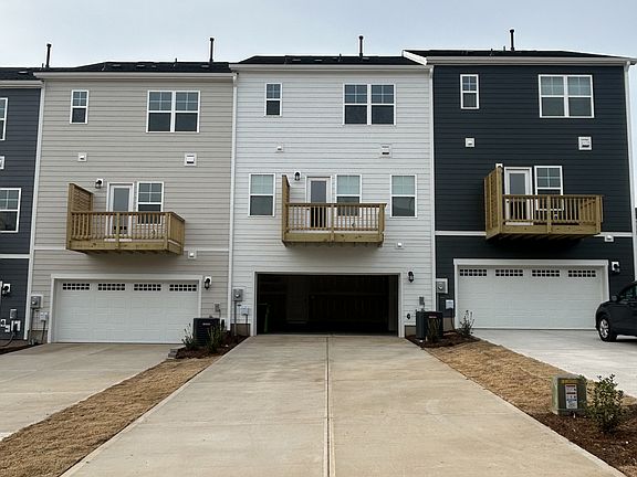 Rear view of home, garage, and driveway