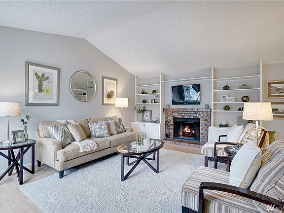 Welcome to your large and well appointed living room. Vaulted ceilings and natural light throughout. Cozy up to this brick wood burning fireplace. Entire Home has all new interior paint. Easy to clean and care for laminate flooring throughout. 