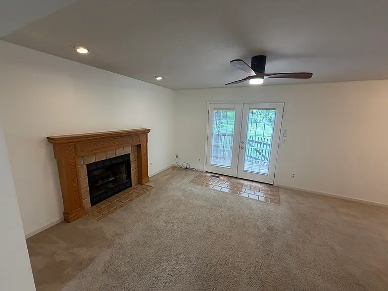 great room with gas log fireplace, brand new ceiling fan and door to deck