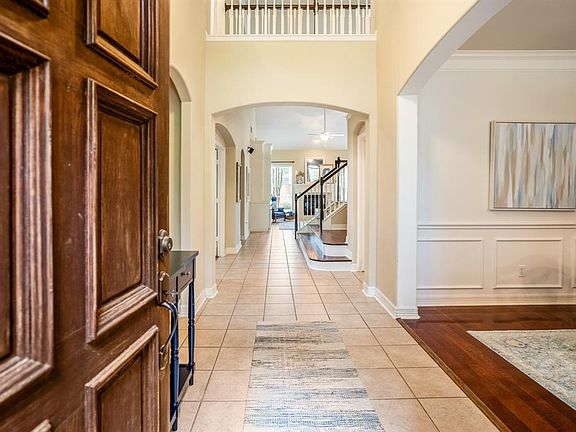 A solid wooden door leads to the entry of the home, nice tiled floor flows through the foyer and into the home.