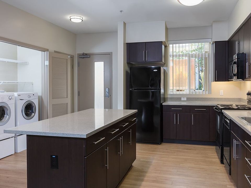 Classic Package I kitchen with black appliances, grey speckled granite countertops, espresso cabinetry, and hard surface flooring