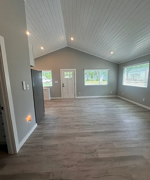 Spacious living & dining area with three large front windows providing natural lighting