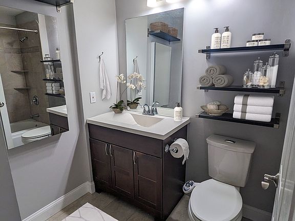 Bathroom with tub/shower combo, ample storage and dual flush toilet with bidet