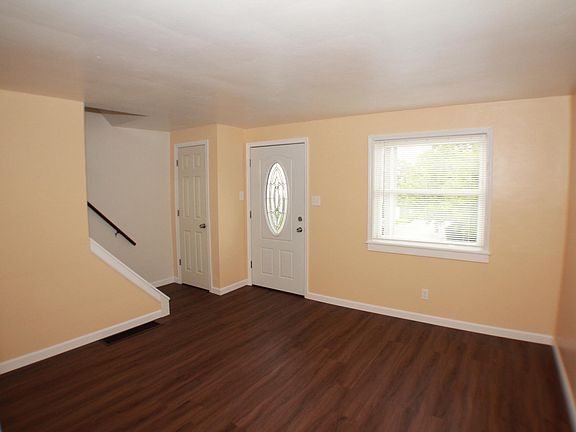 Living room with cut-glass front door and coat closet
