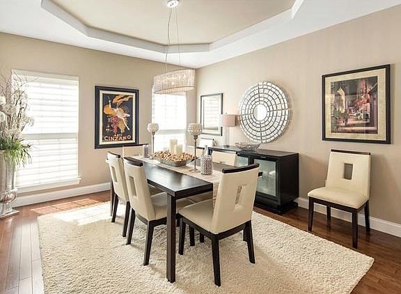 Spacious formal dining room with hardwood flooring, coffered ceiling, upgraded lighting and extra wide base molding.