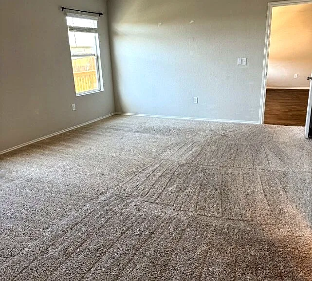 Spacious primary bedroom with natural light and comfortable layout.