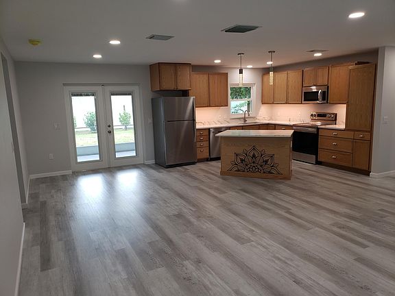 Open concept brand new kitchen with stainless appliances and tons of cabinets