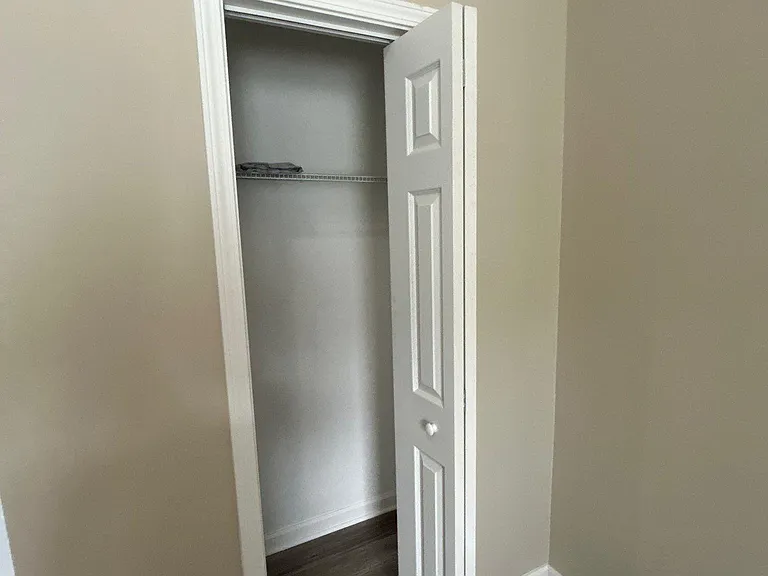 Reach-in closet with hanging shelf and rod, offering convenient in-room storage for clothing and essentials.