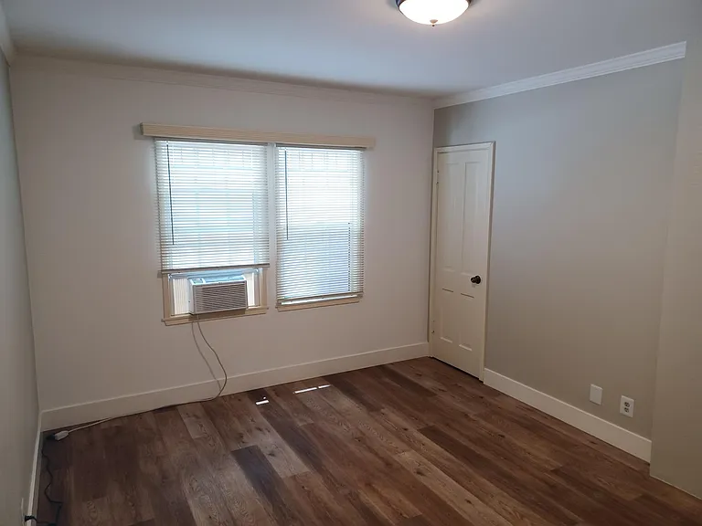 Left side bdrm showing closet door entry, north facing windows, a/c unit.