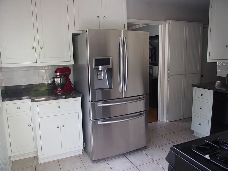 Oversized refrigerator with drink drawer and freezer.