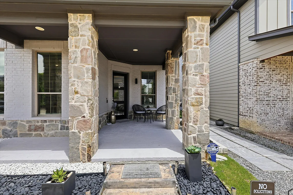 Covered front porch with stone columns and recessed lighting. - 4244 Sechrist Dr