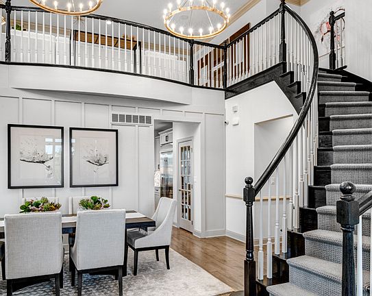 Dramatic entry foyer with curved stair and two-story dining room