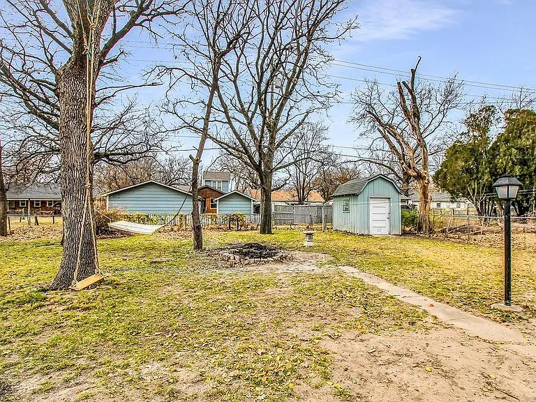 Storage shed in back with a fully fenced chain link around all neighbors and between house and garage. Light outside by sidewalk.