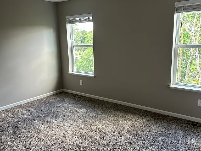 Large primary bedroom with lots of natural light. You can fit a king size bed along with two nightstands on one wall. Still room for a dresser/chest.