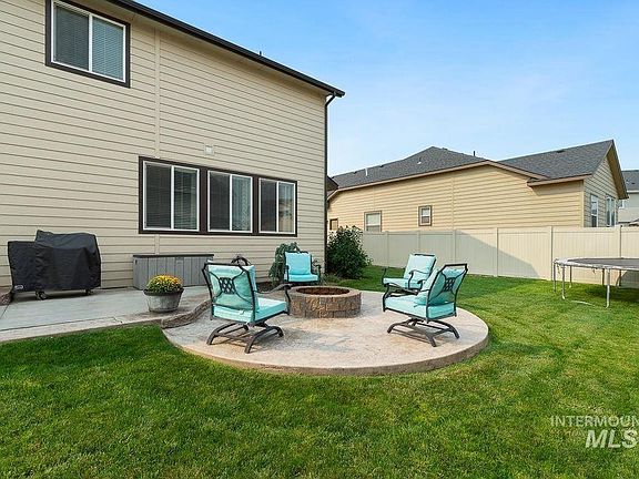 Backyard patio with built-in fire pit to gather around.