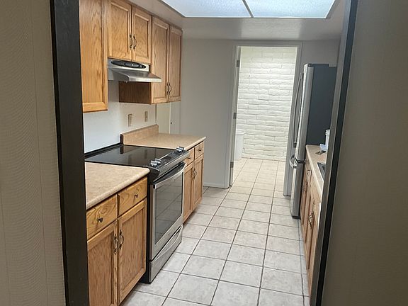 View of kitchen from dining room looking towards utility room where washer and dryer are located.