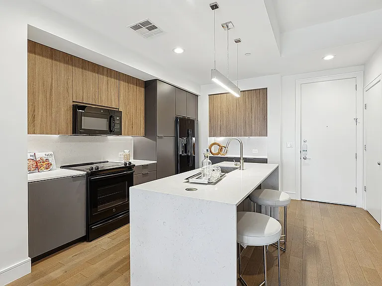 Modern Kitchen with Two-Toned Designer Cabinetry and Waterfall Quartz Island