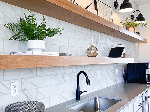 Small touches that make a big difference _ like this backsplash and open shelving setup that brings it all together.