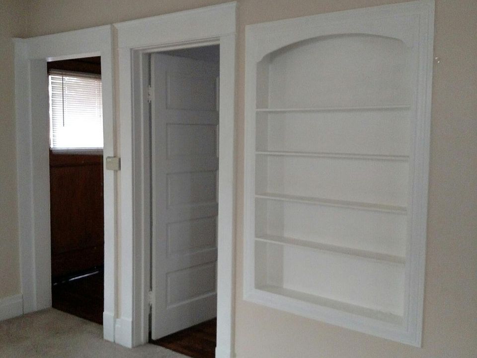 Living room with built in shelves - doorway on the left is to outside and doorway on the right is the secondary bedroom.