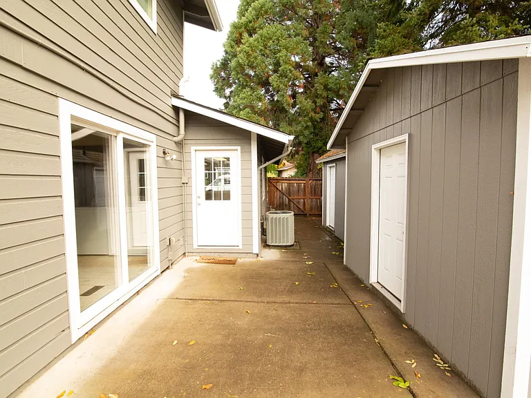 Shed (right) with 2 locking doors and door to the front "bonus room" is the white door straight ahead. Sliding glass doors to the right enter the laundry area/home office.