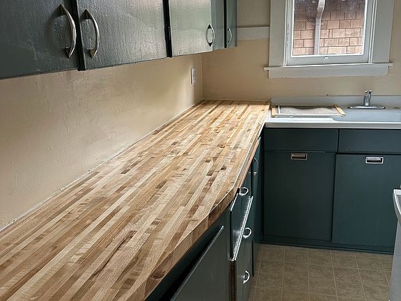 Small narrow kitchen with plenty of storage and brand new butcher block countertop.