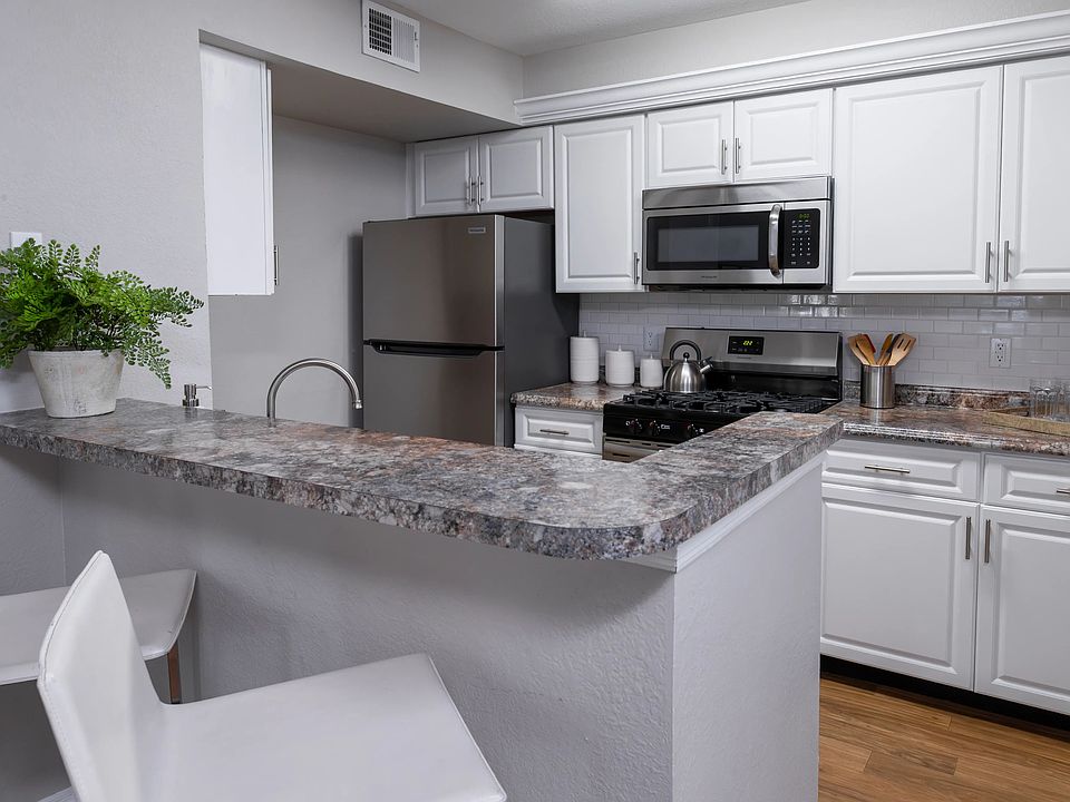 Whip up meals with ease in this stylish kitchen, complete with stainless steel appliances, white cabinetry, and a breakfast bar perfect for casual dining.