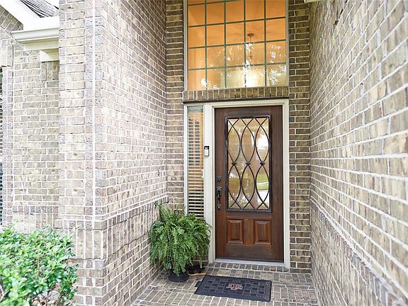 Impressive with brick paved entry, 8 foot mahogany leaded glass door, and interior chandelier shining through above-door window.