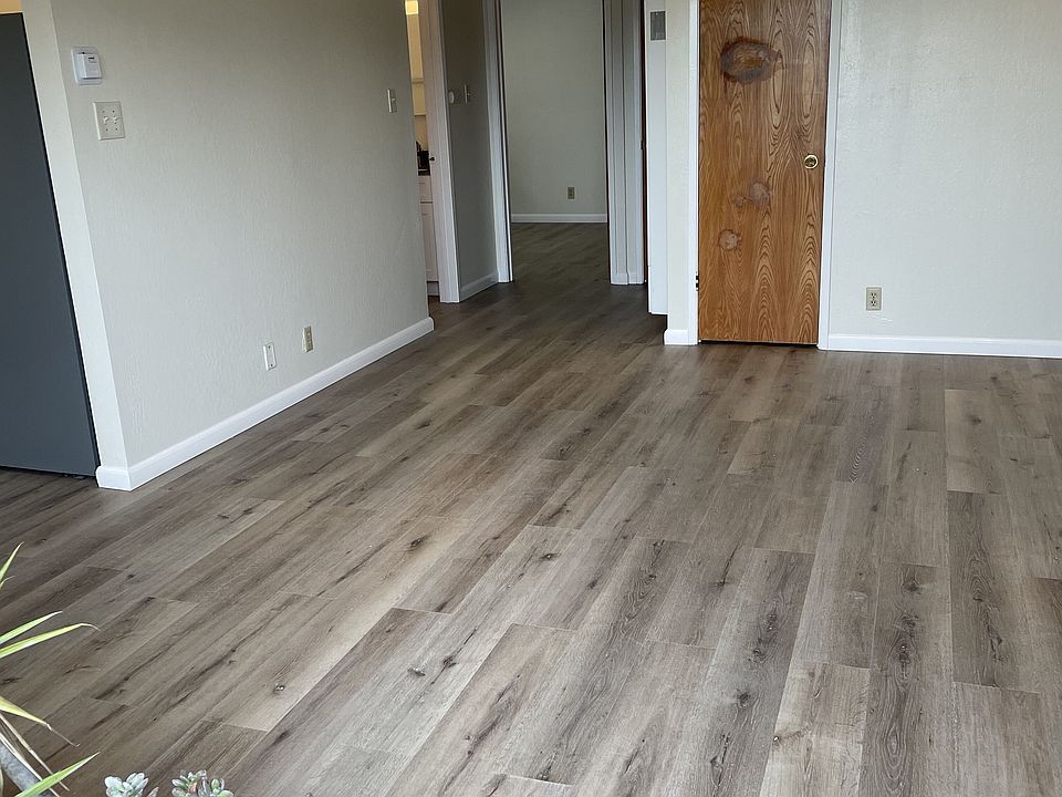Bright and spacious living room with newer LVP flooring and neutral finishes ready for your setup.