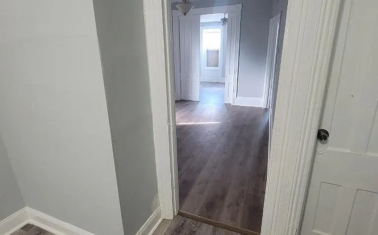 View from kitchen to dining room and front of house (living room). The door on the right leads to the basement.