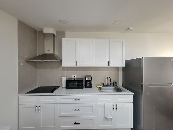 The kitchen includes a refrigerator, coffee maker, extractor hood and basic amenities.