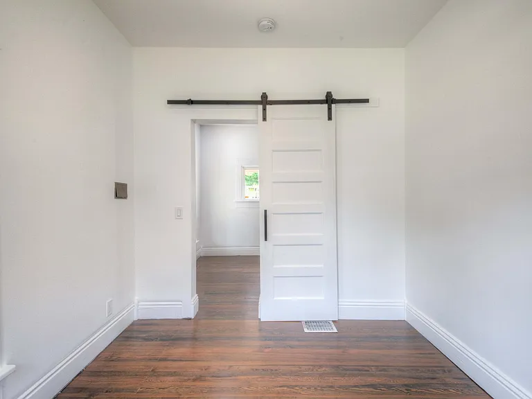 Front bedroom/office with view into living room (barn door).