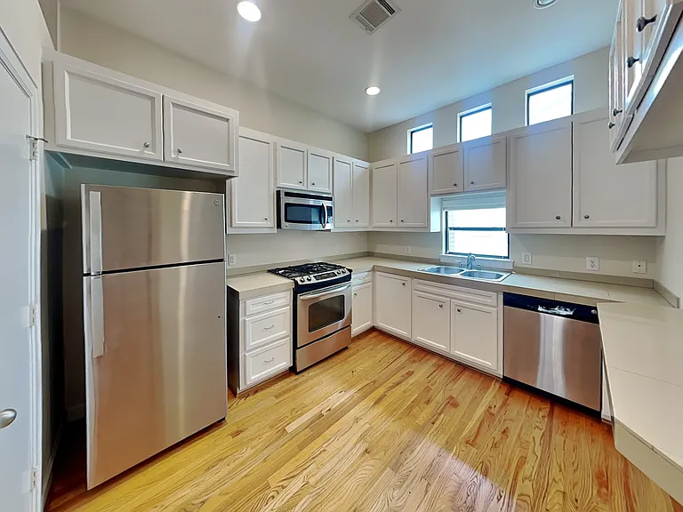 Spacious kitchen with white ca
