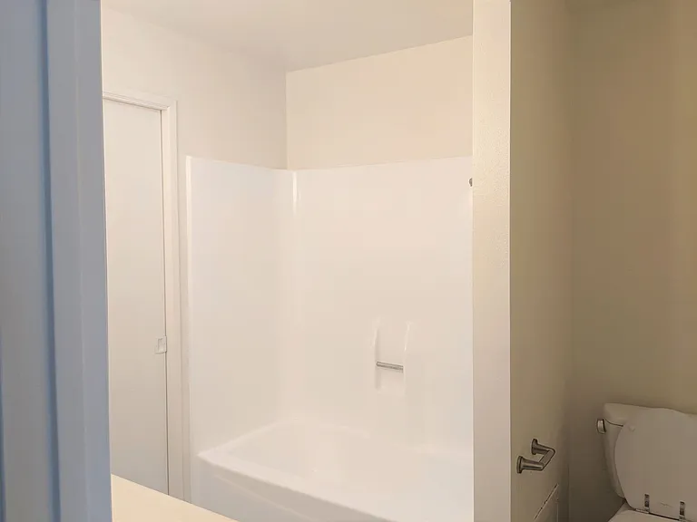 Bathtub shower and toilet in apartment unit at the Steckel Apartments in Santa Paula, California.