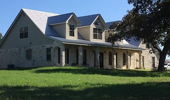 Home is nicely surrounded with trees and grass
