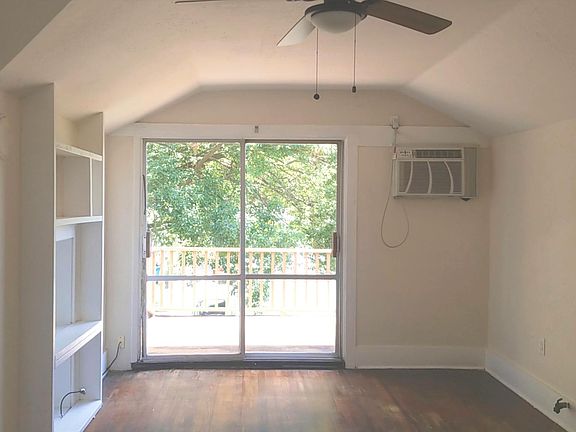 Living room includes dining area, sliding glass door, built in cabinets, ceiling fan and hardwood floors