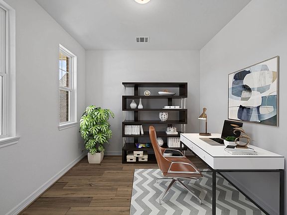 The home office features French doors, beautiful floors, large windows that give a fresh feel, this