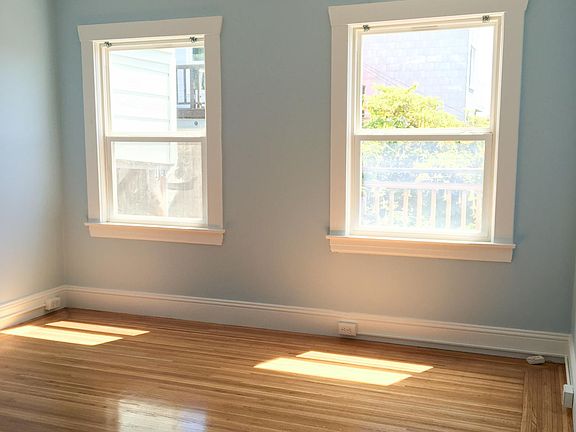 Morning light and original hardwood floors in blue bedroom