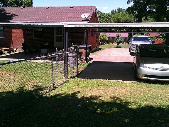 From the back of the yard forward.... Shows the carport and parking area. Also the covered patio and small deck