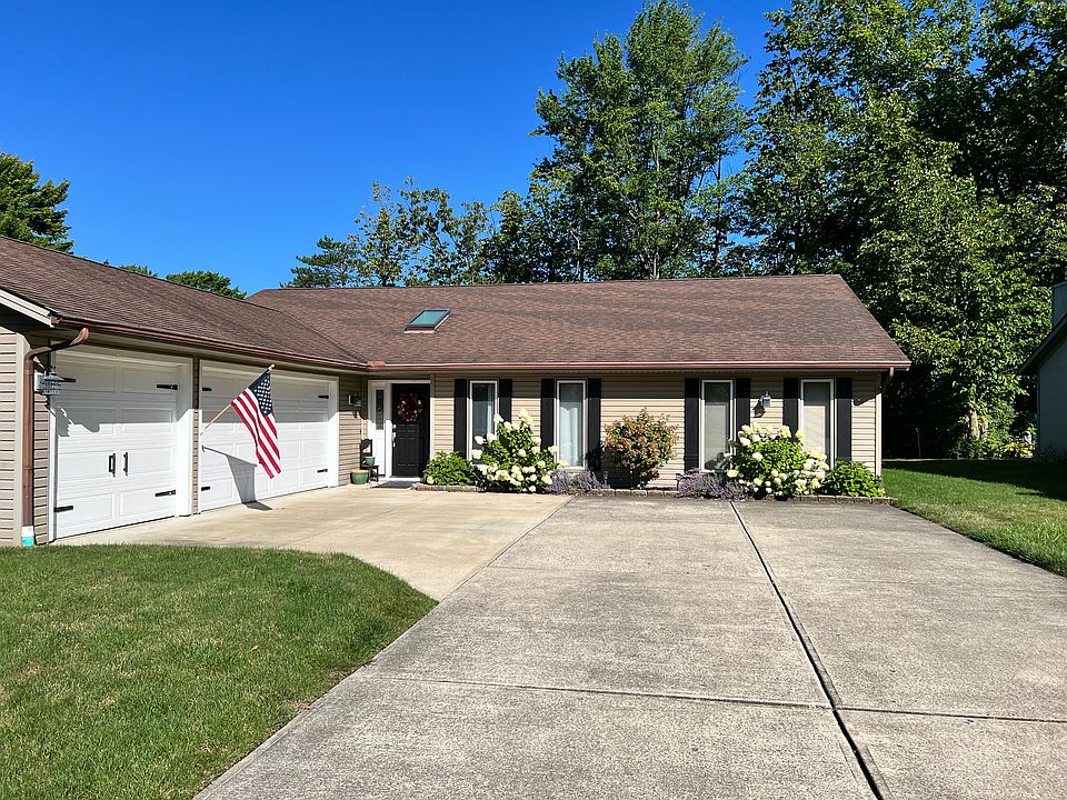 Front is beautifully landscaping with hydrangea bushes and tree.