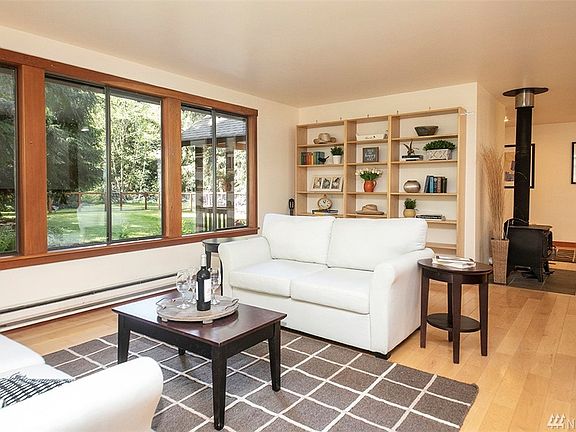 You have just entered the home. Spacious living room w/ an abundance of windows that serve as frames for the natural beauty that surrounds this home. Cozy wood stove heats the entire house when the power goes out (ductless heat pump is main heat source).