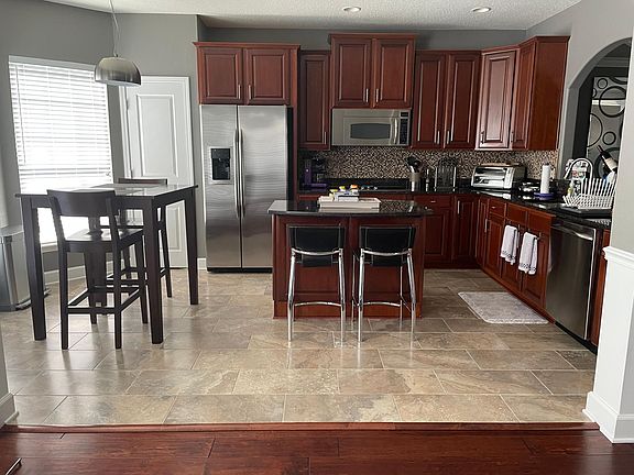 Eat-in kitchen with custom floors and brand-new fridge